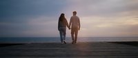 Couple holding hands walking on wooden pier at sunset, romantic relationship and togetherness concept for travel and lifestyle content.