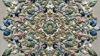 Ornate vintage floral mandala with intricate embroidered design featuring colorful flowers, leaves and decorative elements in symmetrical pattern.
