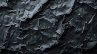 Dark crumpled paper texture with dramatic shadows and folds creating abstract geometric pattern background for modern design and artistic projects.