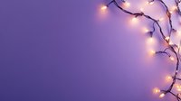Glowing Christmas lights on dark purple background creating festive border frame with copy space for seasonal holiday designs and messages.