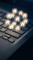 Glowing house icons floating above laptop keyboard representing online real estate search, property listings, digital home buying and virtual housing market.