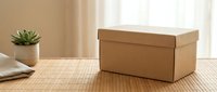 Kraft cardboard box with lid on bamboo mat surface, small succulent plant and folded linen fabric in soft natural home interior.