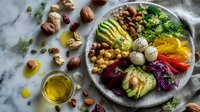Colorful healthy Buddha bowl with quinoa, avocado, roasted vegetables, nuts and seeds on marble background. Nutritious vegan meal prep concept.