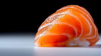 Fresh raw salmon sashimi slice with vibrant orange color and marbled texture on minimalist background, close-up view showing delicate layers of fish.