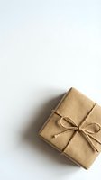 Minimalist brown kraft paper gift box tied with natural twine string on clean white background for eco-friendly packaging and sustainable wrapping concepts.