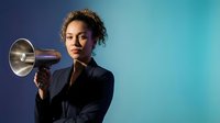 Young African American businesswoman holding megaphone on gradient blue background for marketing and communication campaigns.