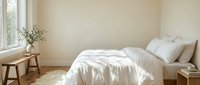 Serene bedroom with white bedding, wooden furniture, and natural light from window, perfect for home decor and interior design projects.