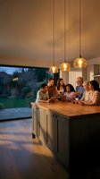 Multi-generational family gathering in modern kitchen with pendant lighting, wooden island countertop, and evening garden views through large windows for home design and lifestyle content.