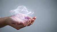 Hand holding glowing holographic sphere with swirling light trails, representing technology, innovation, and digital transformation for business and futuristic concepts.