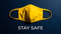 Yellow fabric face mask on dark blue background with Stay Safe text, symbolizing health protection and pandemic awareness.