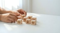Hands arranging wooden blocks with customer service icons on white desk. Business support and client care concept for marketing materials.