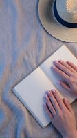Woman hands typing on laptop with straw hat on wooden deck. Summer remote work vacation concept for digital nomad lifestyle and travel blogging.