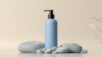 Minimalist spa composition with blue cosmetic pump bottle and natural gray stones on beige background. Skincare and wellness concept.