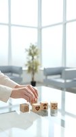 Professional woman arranging wooden blocks with healthcare and legal symbols on modern office desk for business planning and strategy development.