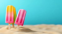 Colorful frozen popsicles on wooden sticks standing in beach sand against bright turquoise background for summer refreshment and vacation treats.