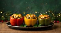 Colorful stuffed bell peppers filled with rice and vegetables on rustic wooden table with festive holiday decorations and evergreen branches.