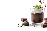 Creamy chocolate mousse dessert in glass with whipped cream, mint leaves and chocolate pieces scattered around on white background. Isolated with copy space.