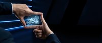 Business professional holding smartphone displaying gear icons representing digital transformation and technology solutions in corporate environment.