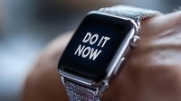 Modern smartwatch displaying motivational message "Do it now" on black screen with metallic mesh band. Close up view shows sleek design and clear digital text.