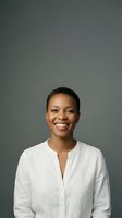 Happy African American businesswoman with short hair smiling confidently in white shirt against gray background for professional headshot portraits.