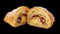 Sliced almond croissant with jam filling, isolated on transparent background. Flaky pastry cut in half, ready for bakery menus, food blogs, stickers, and print on demand.