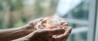 Hands holding glowing geometric crystal sphere with sacred geometry patterns, spiritual energy healing concept for meditation and wellness practices.