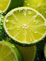 Fresh lime slice with water drops on bright green citrus background, macro photography showing juicy texture and natural freshness for food and beverage designs.