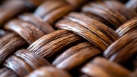Close-up of woven rattan or wicker texture showing natural brown wooden fibers in an interlaced pattern, ideal for furniture design backgrounds.