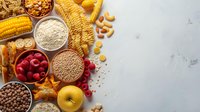 Fresh ingredients and healthy food assortment with grains, fruits, pasta and nuts on light marble background. Clean eating and balanced nutrition concept.