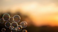 Soap bubbles floating against warm golden sunset sky creating dreamy atmospheric scene for relaxation and mindfulness concepts.