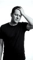 Stressed middle-aged Caucasian man holding head in hand showing headache pain and mental exhaustion isolated on white background for health concepts.