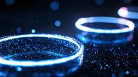 Glowing blue neon rings with sparkles and particles on dark background, abstract light circles with magical luminous effect and bokeh elements.