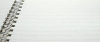 Open spiral notebook with blank lined pages and metal wire binding for writing notes and planning tasks.
