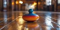 Colorful wooden spinning top with vibrant orange and blue stripes resting on rustic wooden table surface with warm ambient lighting creating nostalgic atmosphere.