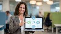 Professional businesswoman presenting digital communication icons on laptop screen in modern office environment for marketing presentations.