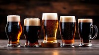 Fresh draft beer collection in different shaped glasses with foam heads on dark wooden background, cold beverages lined up showing variety of craft brews.