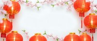Red Chinese lanterns with cherry blossom branches creating decorative border frame on white background for lunar new year celebration and spring festival.
