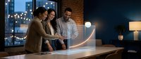 Three diverse business professionals analyzing glowing data visualization curve in modern office environment during evening hours for strategic planning.