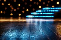 Dark wooden stage floor with glowing blue neon lights and golden bokeh backdrop creates dramatic atmosphere for product display or performance space.
