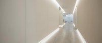 Modern minimalist corridor with clean white walls and LED strip lighting creating elegant architectural interior space for contemporary office design.