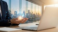 Businessman holding glowing digital database with padlock hologram, cybersecurity and data protection concept in modern office.