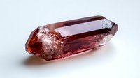 Raw red tourmaline crystal with natural termination and inclusions on white background, showing transparency and deep wine color. Mineral specimen isolated.