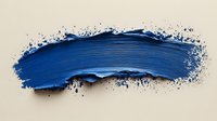 Artistic navy blue paint brush stroke with textured edges and splatter effect on beige background, creating dynamic abstract design element for creative projects.