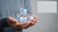 Male hands holding glowing crystal spheres with blue light, representing global connectivity, technology, and digital transformation for business and innovation concepts.