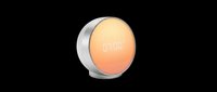 Round sunrise alarm clock with warm orange glow and digital display showing 7:00, isolated on transparent background, ready for T-shirt, sticker, and print on demand use.