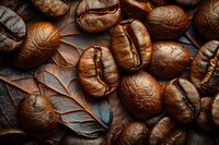 Freshly roasted coffee beans with rich brown color and distinctive groove texture on decorative leaf background for gourmet coffee advertising.