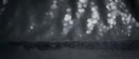Dark textured surface with soft bokeh lights creating dreamy atmosphere for product display and commercial photography backgrounds.
