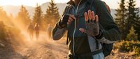 Male hiker with backpack walking on mountain trail at golden hour sunrise, showing stop hand gesture. Adventure trekking concept for outdoor recreation and hiking safety.