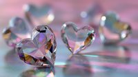 Crystal heart gemstones with rainbow reflections on pink holographic background, creating romantic and luxurious atmosphere for Valentine's Day designs.