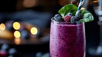 Berry smoothie drink with fresh blackberries and mint leaf garnish, served in glass with blurred bar background for restaurant, cafe, beverage, or cocktail menu design.